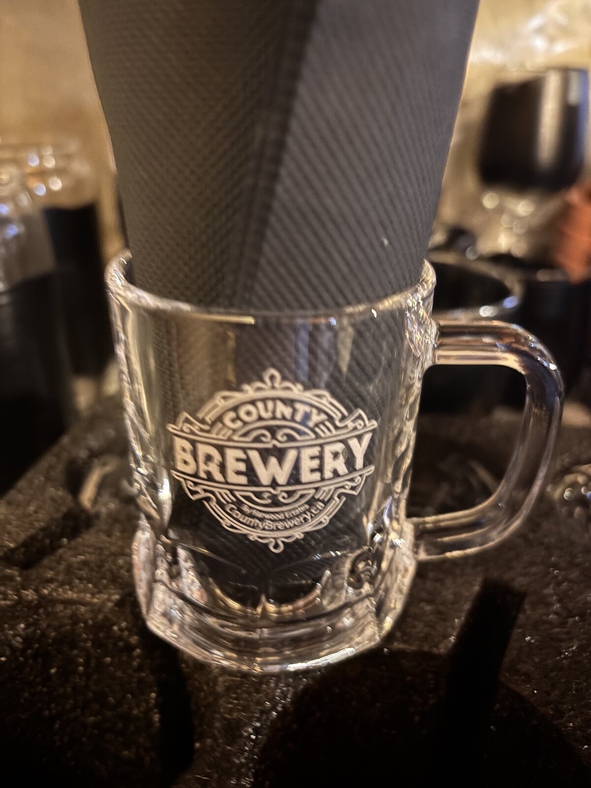 Close-up of a miniature County Brewing Company engraved glass mug
